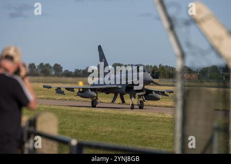 Ein Eurofighter-Taifun fährt auf der Landebahn, während ein Luftfahrthusiast den Moment festhält. Dieses Bild kombiniert die Spannung der militärischen Luftfahrt mit Stockfoto
