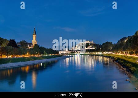 Die Altstadt von Salzburg bei Nacht zur blauen Stunde mit der Festung Hohensalzburg im Hintergrund - mit Salzach Stockfoto