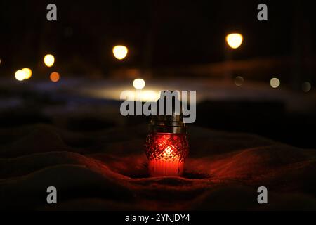 KIEW, UKRAINE - 23. NOVEMBER 2024 - Eine Mahnlaterne leuchtet im Schnee im Holodomor-Museum während der Aktion Licht die Kerze am Gedenktag der Holodomor-Opfer in Kiew, Hauptstadt der Ukraine. Am vierten Samstag im November zollt die Ukraine den Ukrainern Tribut, die während der von Menschenhand verursachten Hungersnot von 1932-1933 und den Massenhungersnöten von 1921-1923 und 1946-1947 getötet wurden, mit einem Moment der Stille und des Anzündens von Kerzen. Der Holodomor wird als Völkermord der ukrainischen Nation anerkannt. Stockfoto