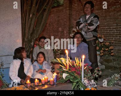 Familie sitzt am Grab eines Verwandten, Kerzenlicht, nachts, Fiesta de Muertos, Friedhof im Dorf Xoxocotlan, nahe Oaxaca, Mexiko Stockfoto