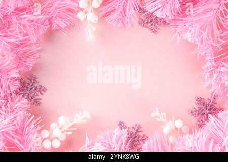 Kitschmas Weihnachtshintergrund mit flauschigen rosa künstlichen Weihnachtsbaumbrunches, rosa festliche Schleife und Dekorationen im trendigen umhüllenden Kitschstil, Stockfoto