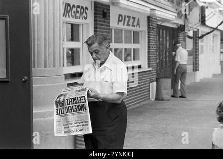 - USA, New Jersey, Asbury Park griechischer Einwanderer, der eine Zeitung liest (Juli 1985)- USA, New Jersey, Asbury Patrk, immigrato greco legge un giornale (Luglio 1985) Stockfoto