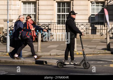 Ein Mann, der mit einem E-Roller über die Waterloo Bridge fährt. Das Fahren mit einem E-Scooter in Privatbesitz ist verboten, außer auf Privatbesitz in Großbritannien. Die einzigen E-s Stockfoto