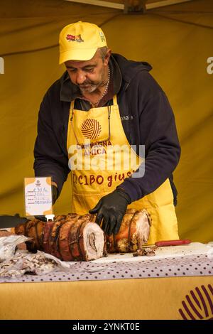 bologna, Italien. 6. Oktober 2024: Anbieter, der Schweinefleisch auf dem Campagna Amica Farmers Market zubereitet Stockfoto