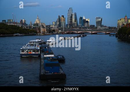 Boote liegen im Zentrum der Themse zwischen Waterloo und Southwark Brücken, mit der Kuppel der St. Pauls Cathedral und den Wolkenkratzern in der Stadt Stockfoto