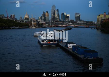 Boote liegen im Zentrum der Themse zwischen Waterloo und Southwark Brücken, mit der Kuppel der St. Pauls Cathedral und den Wolkenkratzern in der Stadt Stockfoto