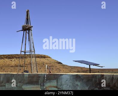 Alte Windmühle neben neuer Solarwasserpumpe am Farmdamm an der Knersvlakte in Namaqualand, Südafrika. Stockfoto