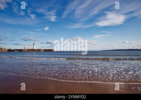 Der Leuchtturm von Scarborough spiegelt sich im blauen Wasser am Scarborough Beach, England. Stockfoto