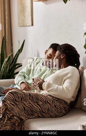 Ein glückliches Paar genießt die Gesellschaft, während es im Winter zu Hause in Wärme gehüllt wird. Stockfoto