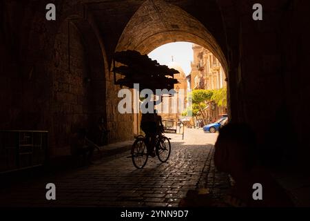 Ein Arbeiter, der Brot auf seinem Fahrrad liefert Stockfoto