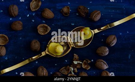 Zwei Gummienten in einem goldenen Nussknacker. Walnüsse und Nussschalen. Stockfoto