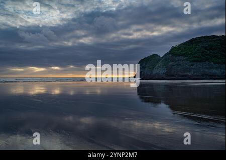 Sonnenaufgang Wolken reflektieren am Te Henga Surf Beach, Auckland, Neuseeland Stockfoto