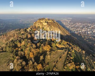 Aus der Vogelperspektive des vulkanischen Kegels Hohentwiel mit der von der Abendsonne beleuchteten Burgruine, dahinter die Stadt Singen am Hohentwiel, Singen A. Stockfoto