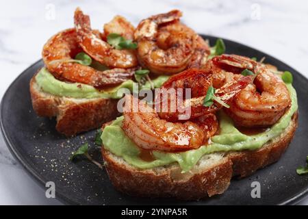 Sandwiches mit Avocado und karamelisierten Garnelen, Micro-Greens, Frühstück, auf einem Teller, Blick von oben, hausgemacht, keine Leute Stockfoto