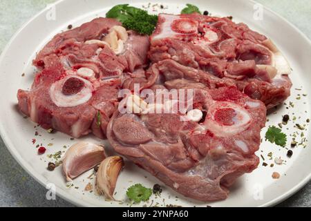 Rohes Steak, Kalbhals auf den Knochen, frisches Fleisch, auf einem weißen Teller, Blick von oben, keine Leute Stockfoto