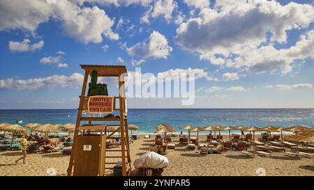 Ein Rettungsschwimmer-Turm am Strand, umgeben von Sonnenschirmen und Liegen, mit einem weiten Blick auf das Meer und den Himmel, Kyra Panagia Beach, Kyra Panagia Beach, East CoA Stockfoto