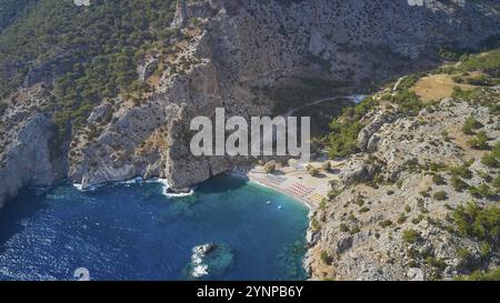 Drohnenaufnahme, aus der Vogelperspektive auf eine abgelegene Bucht mit türkisfarbenem Wasser, umgeben von einer grünen, bewaldeten Küste, Ahata Beach, Ahata, Ostküste, Karpathos Stockfoto