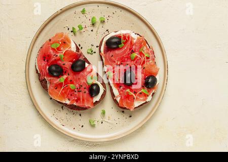 Sandwiches mit rotem Fisch, Frischkäse, Oliven und Mikrogrün, Frühstück Stockfoto