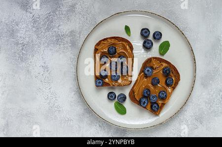 Roggenbrot mit Erdnusspaste und frischen Heidelbeeren, Blick von oben, keine Leute Stockfoto