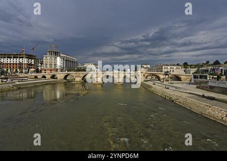 Alte Steinbrücke in Skopje und ein nahendes Gewitter sowie etwas Sonne, die die Brücke beleuchtet Stockfoto