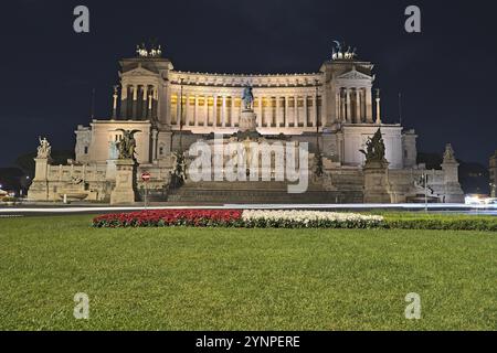 Blick auf die Altare della Patria von der Piazza Venezia bei Nacht und Autos überqueren Stockfoto