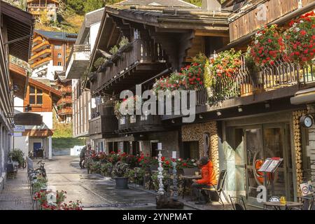 Zermatt, Schweiz, 7. Oktober 2019: Blick auf die herbstliche Stadt im berühmten schweizer Skigebiet, farbenfrohe traditionelle Häuser, Berge und Menschen, Europa Stockfoto