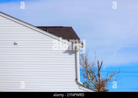 Helle weiße Holzecke steht vor scharfen architektonischen Linien in der Nähe von Bäumen, die Hinweise geben Stockfoto
