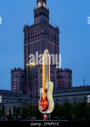 Warschau, masovia, Polen - 16. April 2024: Hard Rock Cafe Neongitarre und Palast für Kultur und Wissenschaft in Warschau. Stockfoto