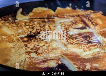 Der goldbraune Kaiserschmarrn, ein traditionelles österreichisches Pfannkuchengericht, brutzelt in einer Pfanne auf dem Zürcher Weihnachtsmarkt in der Schweiz Stockfoto