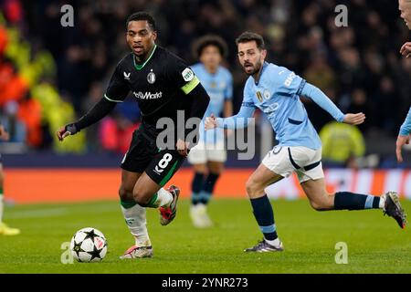 Manchester, Großbritannien. November 2024. Quinten Timber aus Feyenoord mit dem Ball vor Bernardo Silva aus Manchester City während des UEFA Champions League-Spiels im Etihad Stadium in Manchester. Der Bildnachweis sollte lauten: Andrew Yates/Sportimage Credit: Sportimage Ltd/Alamy Live News Stockfoto