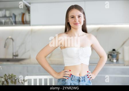 Porträt einer langhaarigen jungen Frau, die in der Küche steht Stockfoto