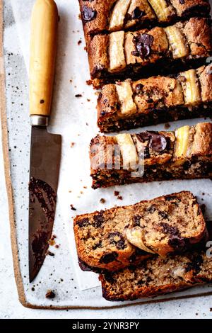 Geschnittenes Bananenschokoladenbrot auf einem Schneidebrett mit einem Messer daneben. Stockfoto