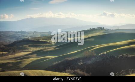 Landschaft in der Toskana mit Bauernhof und sanften Hügeln an einem Winternachmittag. Ein typischer Blick auf das Val d'Orcia. Der Berg Amiata im Hintergrund, Italien Stockfoto