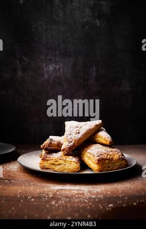 Apfelumschläge mit Puderzucker auf Holzoberfläche Stockfoto