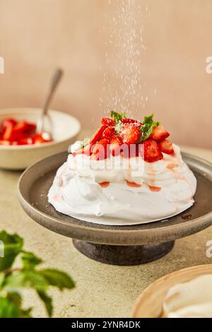 Pavlova mit Erdbeere und Minze mit Creme auf einer grauen Servierplatte Stockfoto