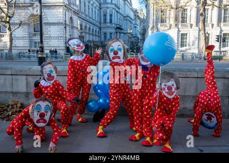 Aktivisten tummeln sich und jonglieren, während sie als Clowns gekleidet sind und die letzten sieben britischen Premierminister-Masken vor der Downing Street in London tragen. PETA-Aktivisten (People for the Ethical Treatment for Animals) sind als Clowns gekleidet und trugen die letzten sieben britischen Premierminister-Masken (Gordon Brown, David Cameron, Theresa May, Boris Johnson, Elizabeth Truss, Rishi Sunak und Tony Blair). Aktivisten rufen Keir Starmer und die Labour-Regierung auf, ihr Wahlversprechen zu erfüllen, die Tierversuche zu reduzieren oder gar zu stoppen. Stockfoto