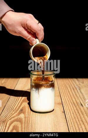 Eiskaffee von Hand in Glas gießen. Stockfoto