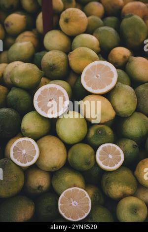 Ein Haufen Zitronen auf dem sizilianischen Markt. Hälften und ganze Zitronen Stockfoto