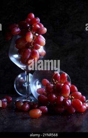 Rote Trauben in Weingläsern. Stillleben auf dunklem Hintergrund. Stockfoto