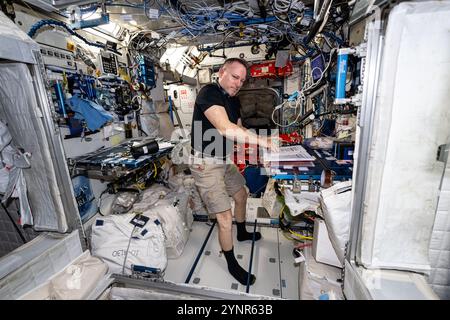 Internationale Raumstation, Erdumlaufbahn. 25. Oktober 2024. Der NASA-Astronaut und Expedition 72 Flight Engineer Butch Wilmore arbeitet im Harmony-Modul und druckt und aktualisiert die Notfallverfahren der ISS an Bord der Internationalen Raumstation am 25. Oktober 2024 in der Erdumlaufbahn. Quelle: Astronaut bereitgestellt/NASA/Alamy Live News Stockfoto