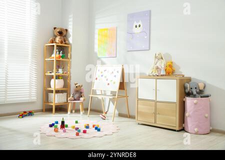 Wunderschöne Einrichtung im Kinderzimmer mit Spielzeug und stilvollen Möbeln Stockfoto
