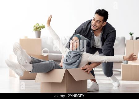 Emotionale Familie aus dem Nahen Osten, die Spaß beim Auspacken hat Stockfoto
