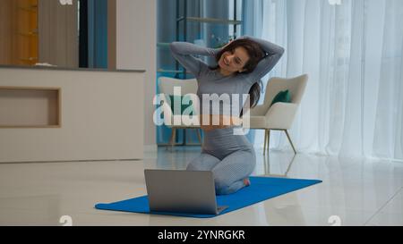 Kaukasisches Mädchen Athlet Fitness Instruktor Happy Woman Coach Tutorial Online-Klasse Yoga Pilates Training unterrichten Übung mit Laptop weiblichen Sport Stockfoto