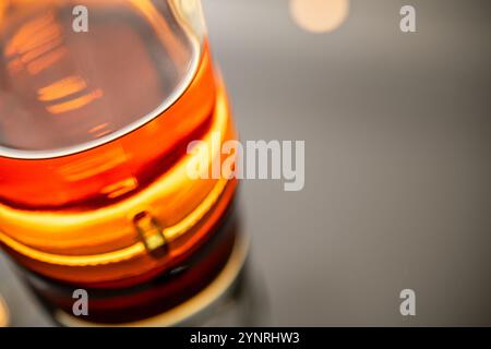 Nahaufnahme von Bernstein Whiskey in einem Glas, die luxuriöse Textur, Farbe und Reflexionen enthüllt. Ideal für Artikel über Getränke, feines Trinken, Craftin Stockfoto