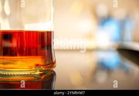 Erkunden Sie eine Nahaufnahme einer Premium Whiskey Flasche, die seine satte Bernsteinfarbe und Reflexionen für kulinarische, Getränke- und Lifestyle-Fotografie zeigt Stockfoto