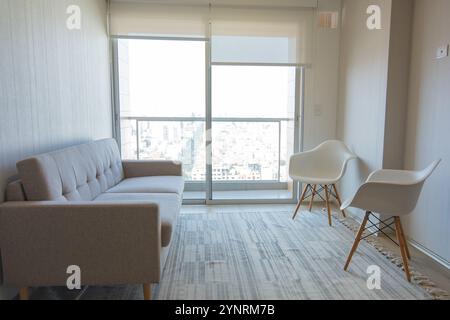 Ein Wohnzimmer mit einer weißen Couch und zwei weißen Stühlen. Neues Hauskonzept. Stockfoto
