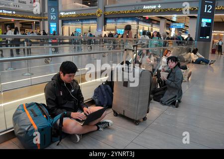 New York, Usa. November 2024. Zwei Tage vor dem Erntedankfest sitzen die Menschen in der Moynihan Train Hall in Manhattan, New York City. Da Thanksgiving naht, fahren viele Reisende in New York City zu Verkehrsknotenpunkten. Es wird erwartet, dass die Anzahl der Reisenden in dieser Urlaubswoche den Verkehr an Bahnhöfen, Busbahnhöfen und Flughäfen verursacht. (Foto: Jimin Kim/SOPA Images/SIPA USA) Credit: SIPA USA/Alamy Live News Stockfoto