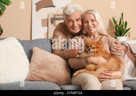 Glückliches Seniorenpaar mit süßem Pommerschen Hund zu Hause Stockfoto