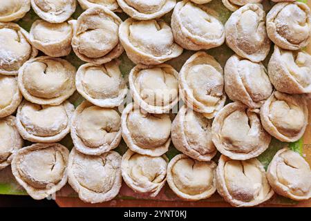 Hausgemachte, rohe Teigtaschen, handgemacht, in Reihen angeordnet. Stockfoto
