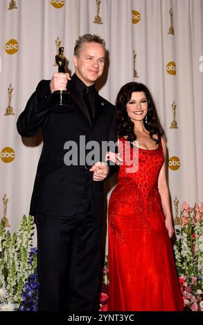 HOLLYWOOD, CA: (L-R) Tim Robbins mit seinem Oscar® für den besten Schauspieler in Einer Nebenrolle für seine Darstellung von Dave Boyle in „Mystic River“ auf der Bühne mit Moderatorin Catherine Zeta-Jones im Presseraum der 76. Annual Academy Awards® im Kodak Theatre in Hollywood, Kalifornien am 29. Februar 2004. © Lee Roth / Roth Stock Celebrity Archives Stockfoto